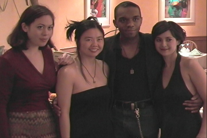 Four cast and crew members posing together at a restaurant table — Watershed (1999)